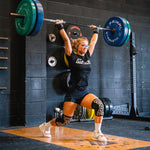 Person lifting a barbell in a gym setting
