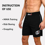 Black athletic shorts with logos on a person, labeled for MMA training, kickboxing, and grappling.